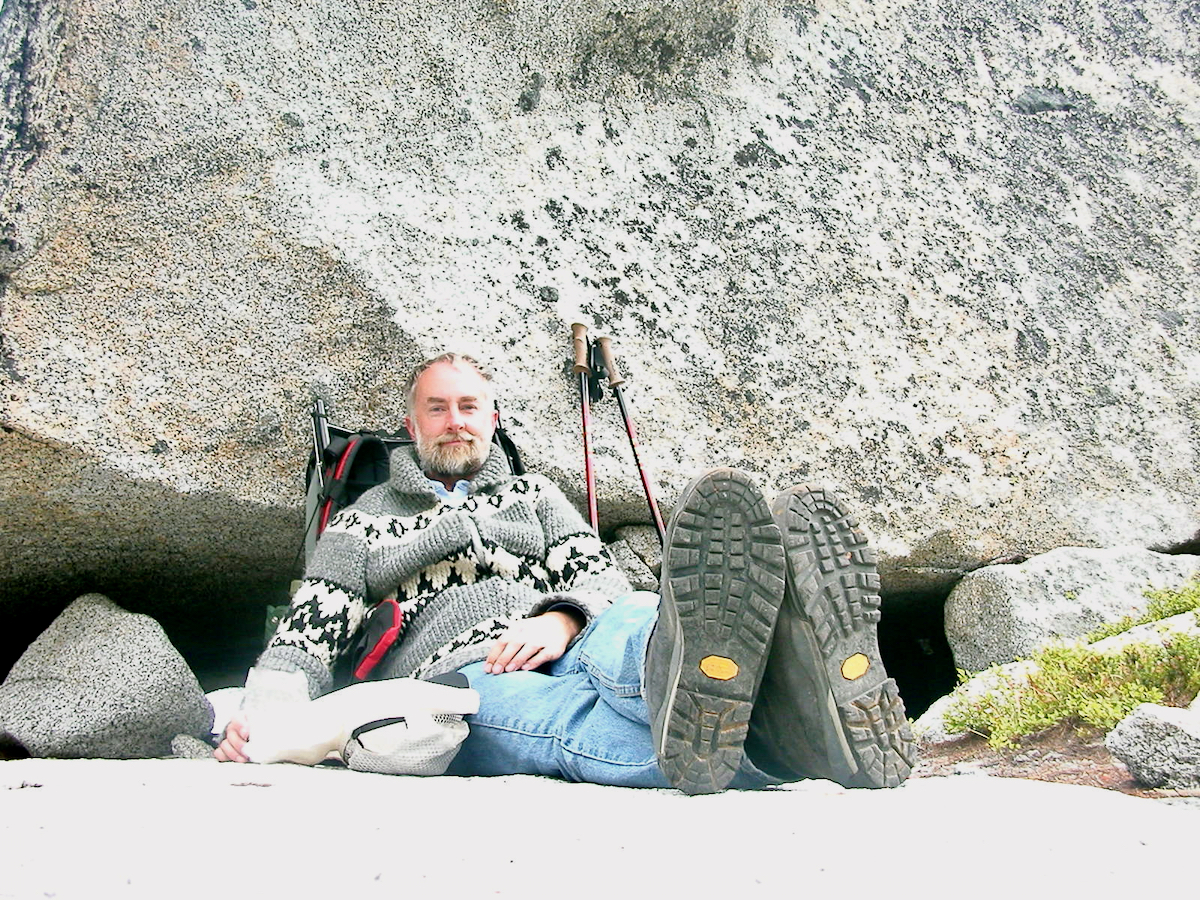 Larry leaning back against a boulder