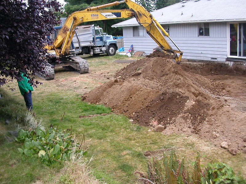 Track hoe digging in back yard