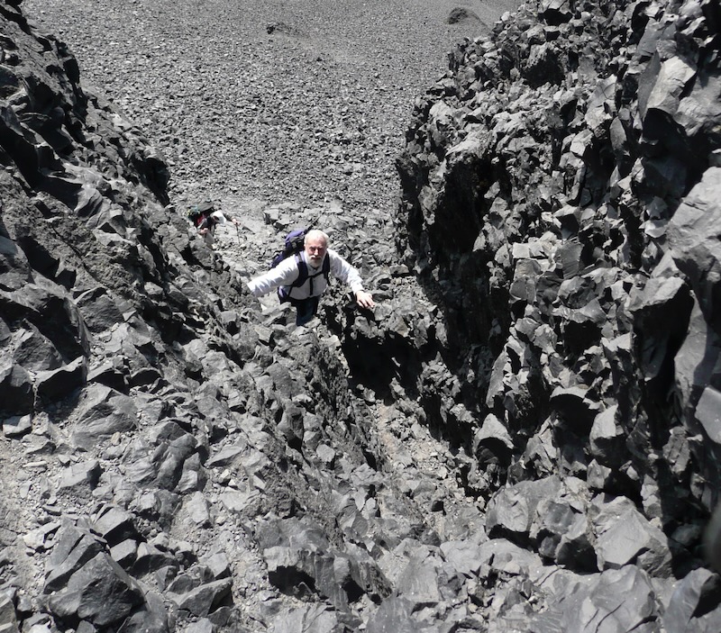 looking down on Larry climbing textured rocks