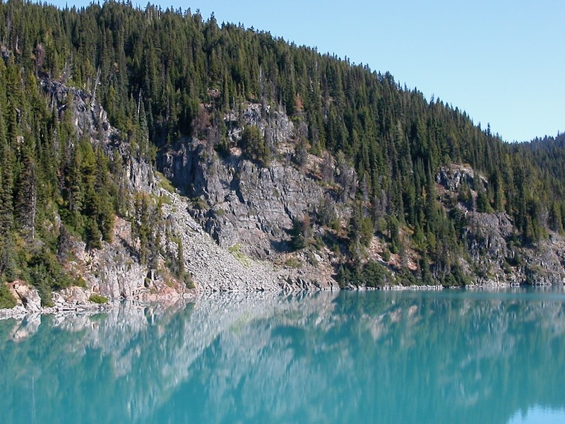 colored lake and treed hill