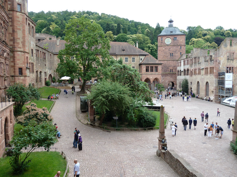 Cobbles, trees, some grass surrounded by castle buildings