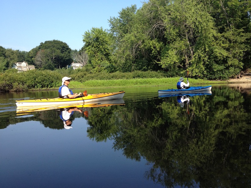 David kayaking on still river in sun