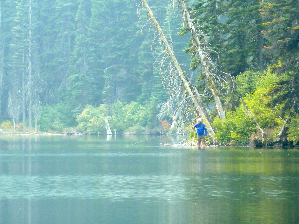 fisherman wading in lake