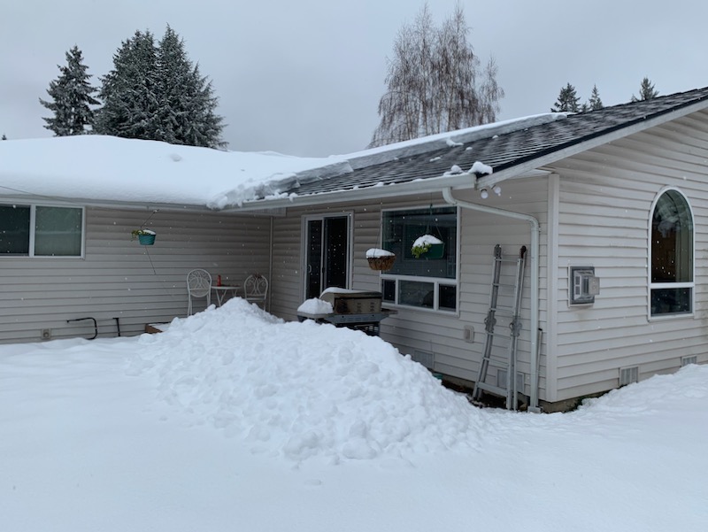 Roof half cleared of snow