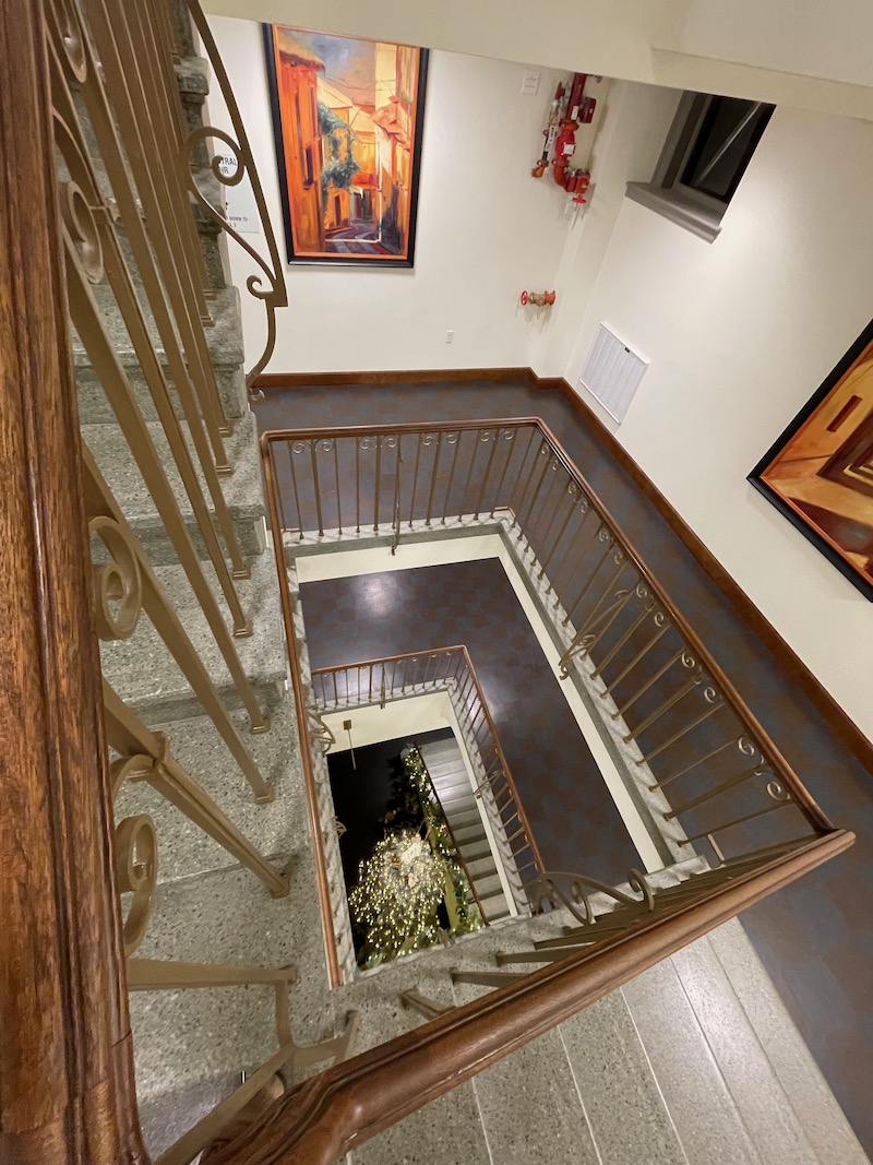 looking down the staircase with decorated tree below