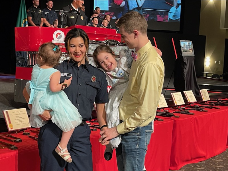 Andrew having put Bethany's firefighter badge on her, with their girls