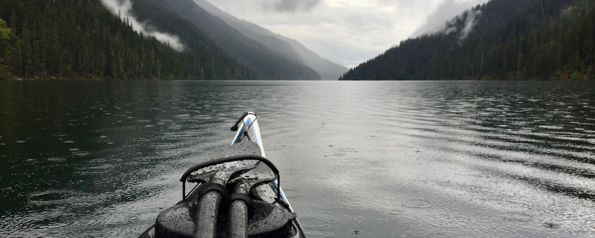 kayak bow and rain-spotted lake