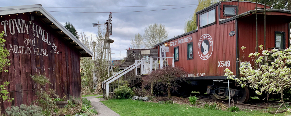 old building, water wind mill, and caboose