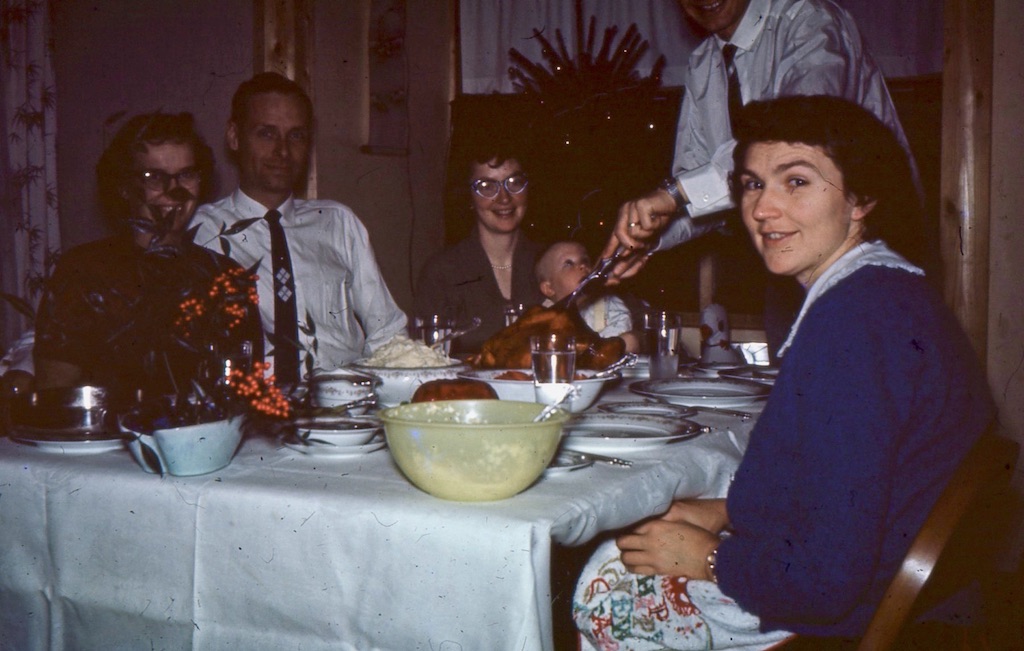 Dad carving turkey with Larry looking